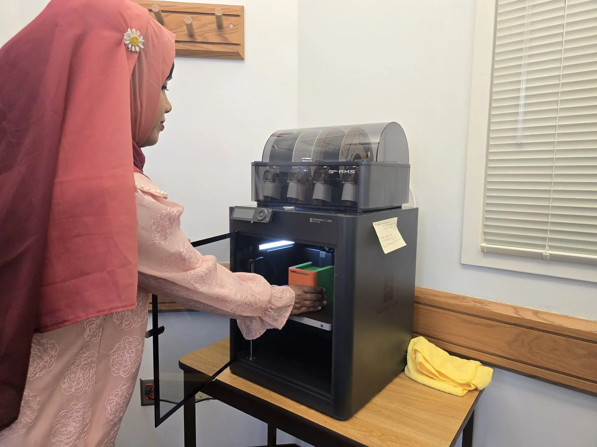 Researcher beside the lab’s Bambu Lab P1S 3D printer and filament system