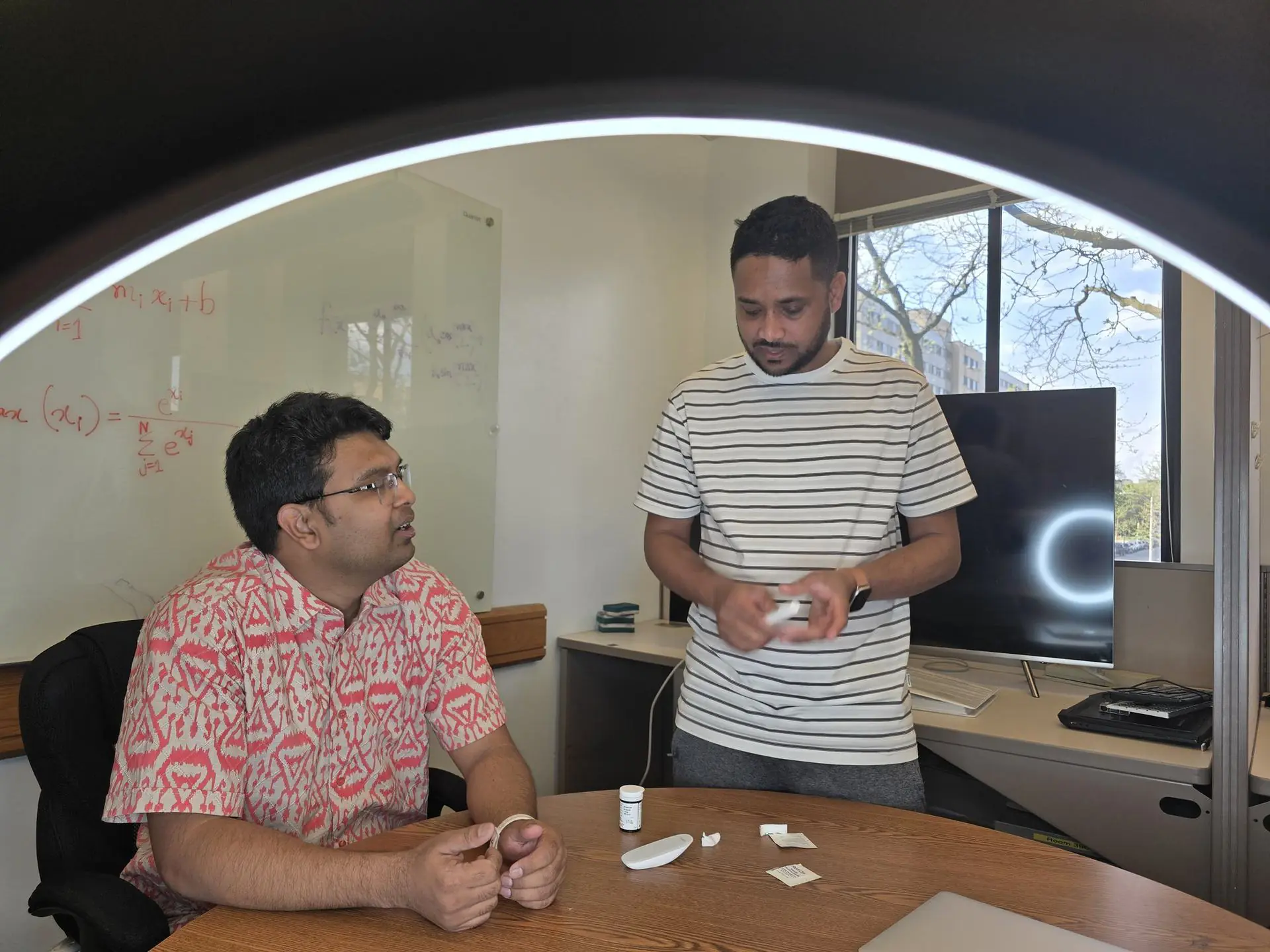 Researchers working with a ring light and camera setup for optical sensing